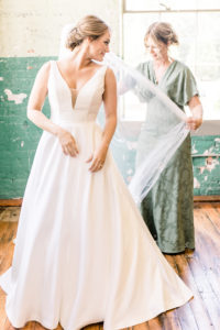 Bride getting dressed during an emotional wedding morning moment captured through documentary Atlanta wedding photography