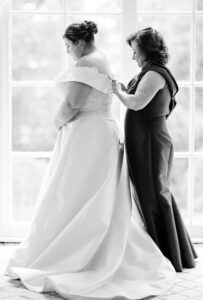 Emotional wedding photo of a parent helping the bride prepare before the ceremony captured by a Luxury Atlanta Wedding Photographer