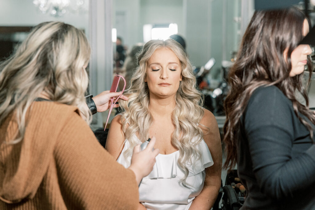 bride having makeup applied from side angle during bridal getting ready photos in Atlanta