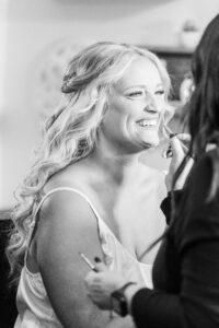 black and white photo of bride getting makeup done during quiet wedding morning getting ready in Atlanta