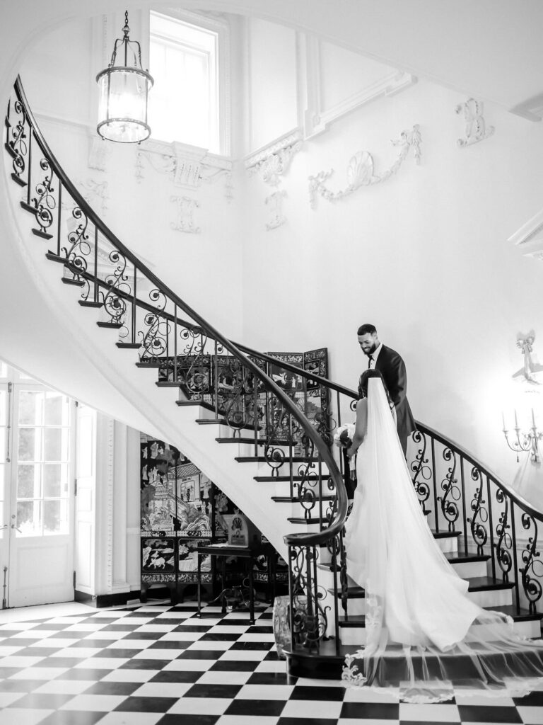 Black and white editorial portrait of bride and groom on Swan House staircase at Atlanta History Center