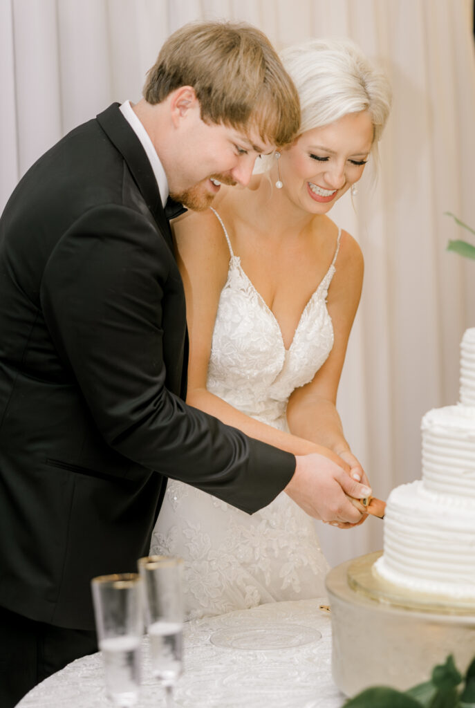Bride and groom cutting wedding cake during elegant private estate wedding reception in Lake Mary