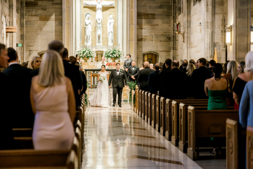 Bride and groom walking down the aisle after ceremony at Christ the King Cathedral in Atlanta