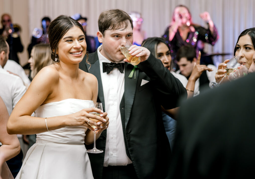 Joyful wedding reception celebration with live band and champagne at Capital City Club