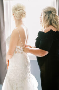 Bride having her wedding dress fastened during intimate getting ready moments at a private Lake Mary wedding