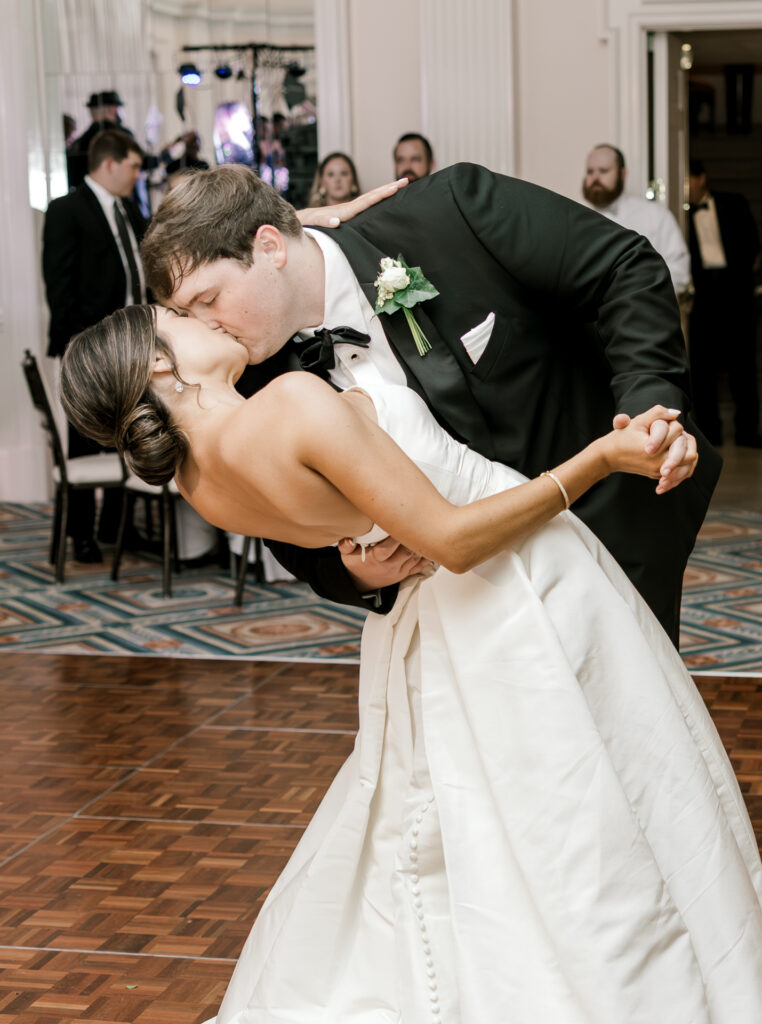 Romantic first dance dip and kiss during elegant Atlanta wedding reception