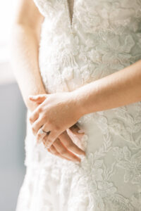 Soft bridal detail photograph featuring hands lace gown texture and natural window light at a private estate wedding