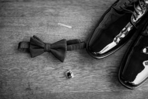 Black and white groom wedding details with tuxedo shoes bow tie and ring at a private Lake Mary wedding