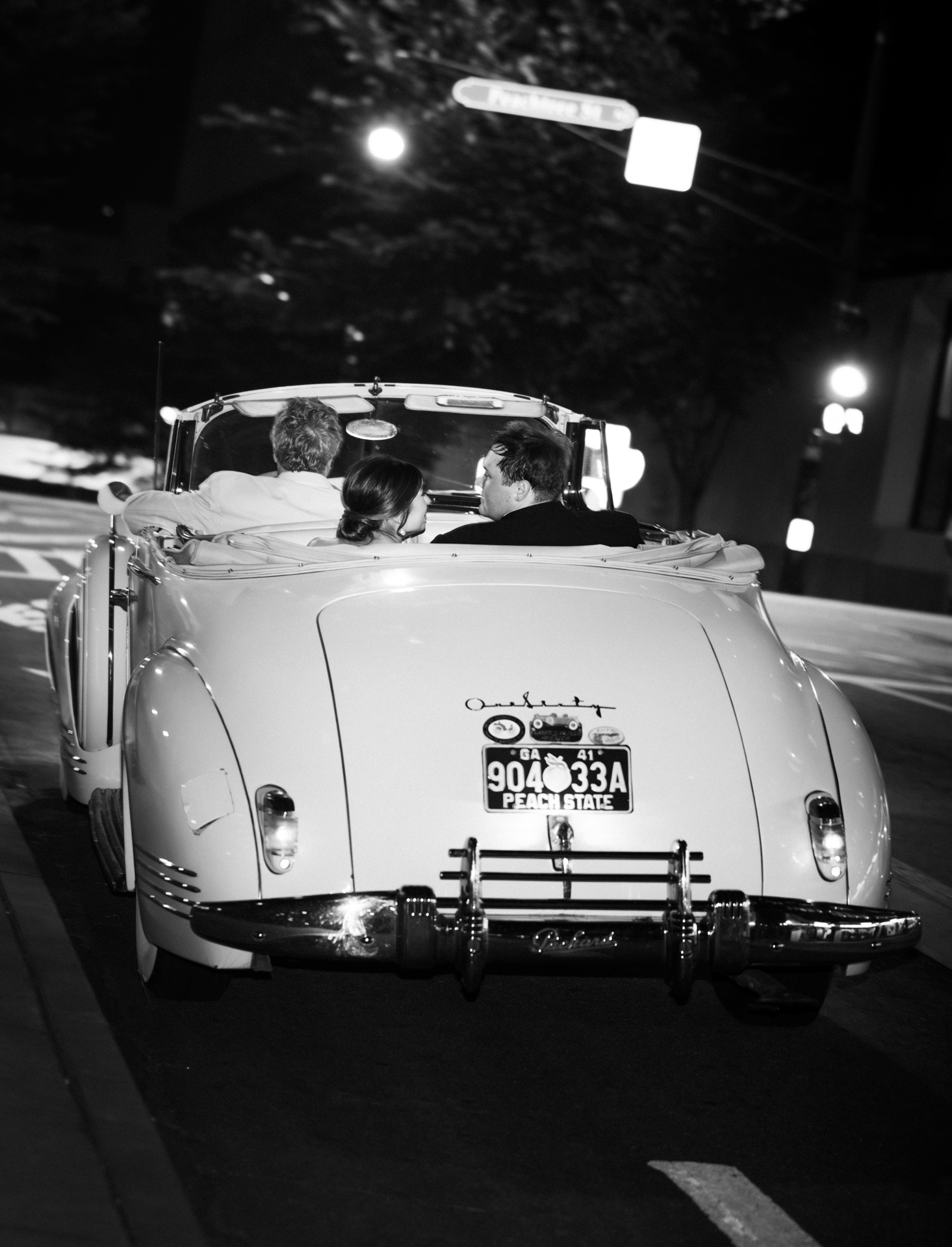 Romantic black and white getaway car wedding exit photo in downtown Atlanta at night