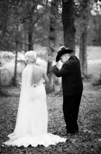 Black and white photograph of a bride and her father embracing before a private estate wedding ceremony at Lake Mary