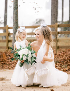 Bride smiling with flower girls during outdoor bridal portraits at a private estate wedding