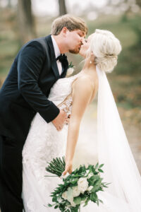 Bride and groom sharing a romantic kiss during outdoor wedding portraits at a private estate wedding