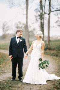 Bride and groom walking hand in hand during romantic private estate wedding portraits at Lake Mary