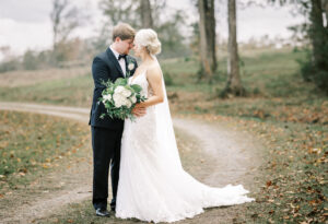 Bride and groom embracing on a countryside path during a private estate wedding at Lake Mary