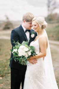 Bride and groom embracing during soft editorial wedding portraits at a private estate wedding
