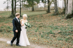 Bride and groom walking together through autumn scenery during a private Lake Mary wedding