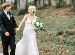 Bride and groom walking together during joyful outdoor portraits at a private estate wedding