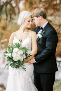 Bride and groom embracing during elegant outdoor portraits at a private estate wedding