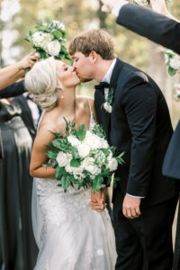 Bride and groom kissing while guests celebrate during their private Lake Mary wedding exit