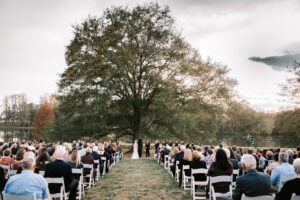 Symmetrical view of guests seated during an elegant outdoor private estate wedding ceremony at Lake Mary