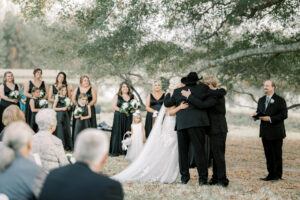 Bride and family sharing an emotional embrace during an outdoor private estate wedding ceremony