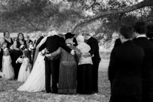 Family members embracing in prayer during an emotional moment at a private estate wedding ceremony in Lake Mary