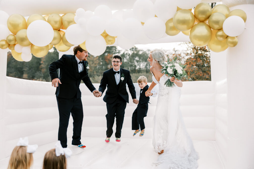 Bride and groom laughing with family inside a wedding bounce house during a private Lake Mary wedding reception