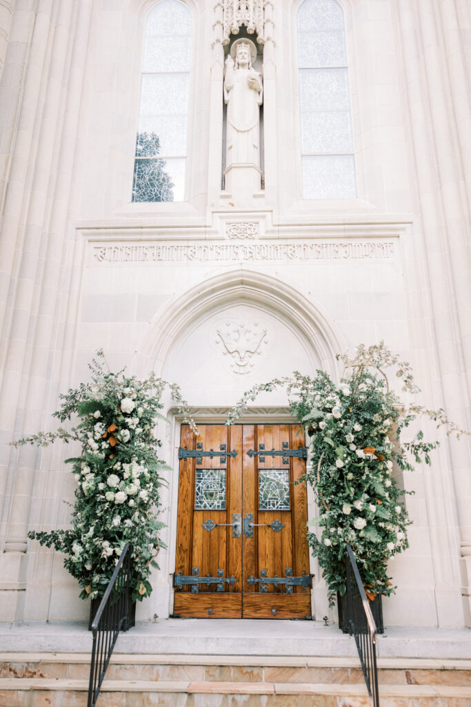 Architectural doorway of Christ the King Cathedral adorned with wedding flowers in Atlanta Georgia