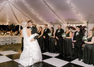 Bride and groom sharing their first dance beneath string lights at a private Lake Mary wedding reception