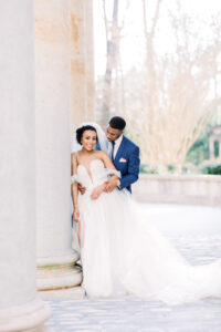 Timeless Swan House wedding portrait of bride and groom framed by historic columns by a luxury documentary Atlanta wedding photographer