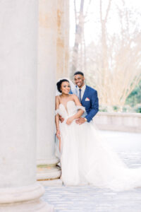 Bride and groom sharing a romantic moment between the iconic Swan House columns captured by a luxury documentary Atlanta wedding photographer