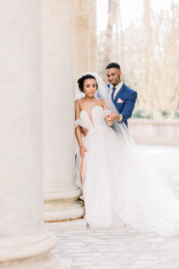 Luxury documentary Atlanta wedding photographer capturing bride and groom beneath the grand stone columns at Swan House in Atlanta