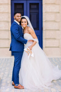 Bride and groom walking away together at Swan House with the bride holding her shoes and smiling during a timeless wedding moment captured by a luxury documentary Atlanta wedding photographer