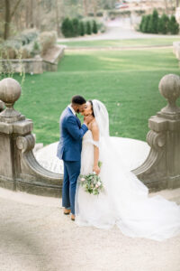 Bride and groom sharing a romantic kiss above the iconic multi-tier fountains at Swan House captured by a luxury documentary Atlanta wedding photographer
