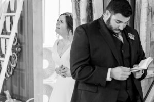 Emotional wedding photo of a groom reading private vows before the ceremony