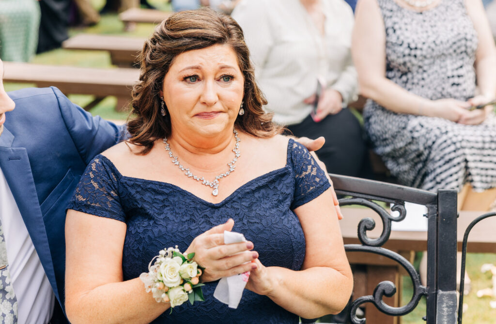 Emotional wedding photo of a mother becoming tearful during an outdoor ceremony captured through documentary Atlanta wedding photography